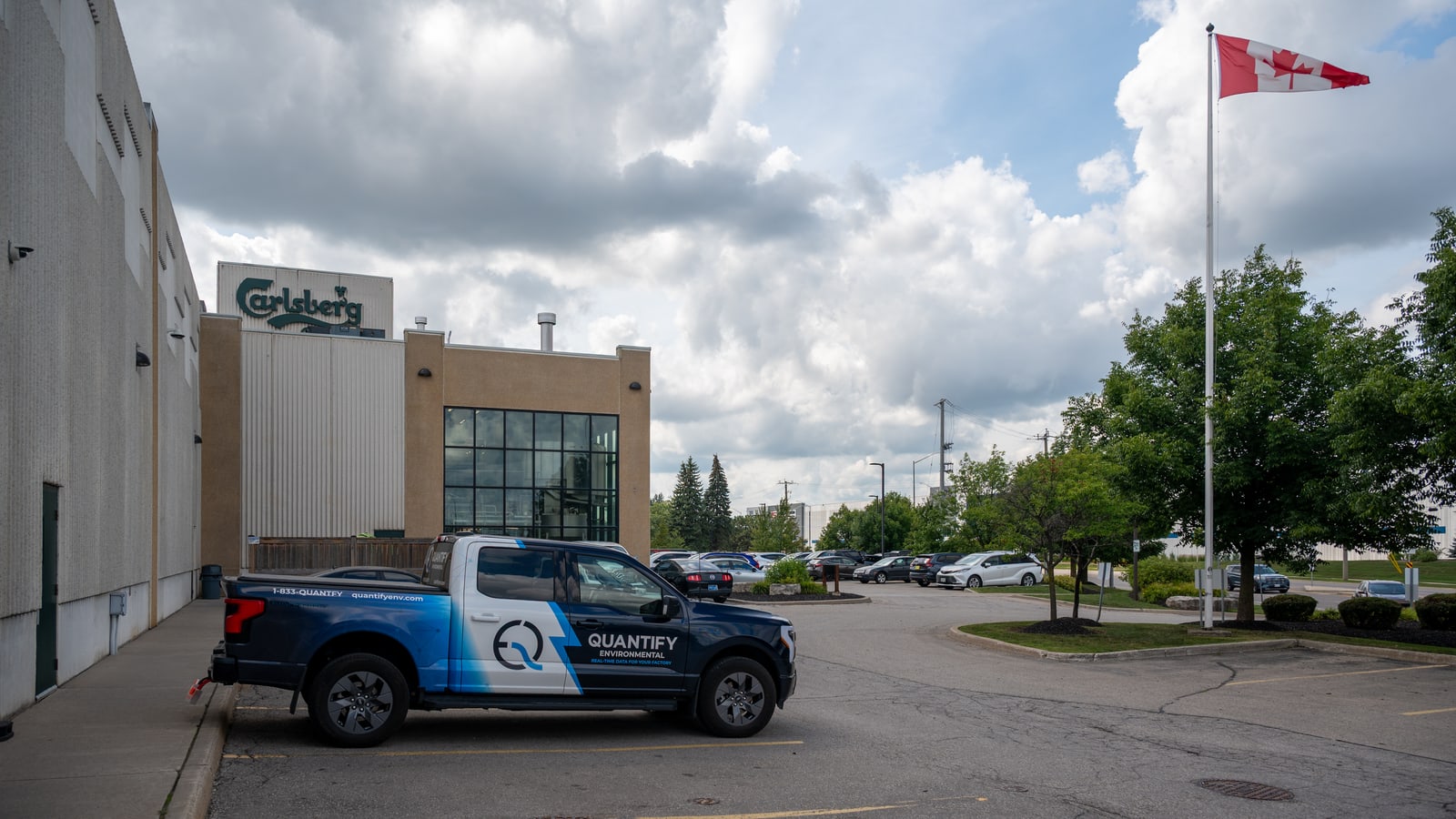 The Quantify truck parked outside the Carlsberg plant under a bright overcast sky